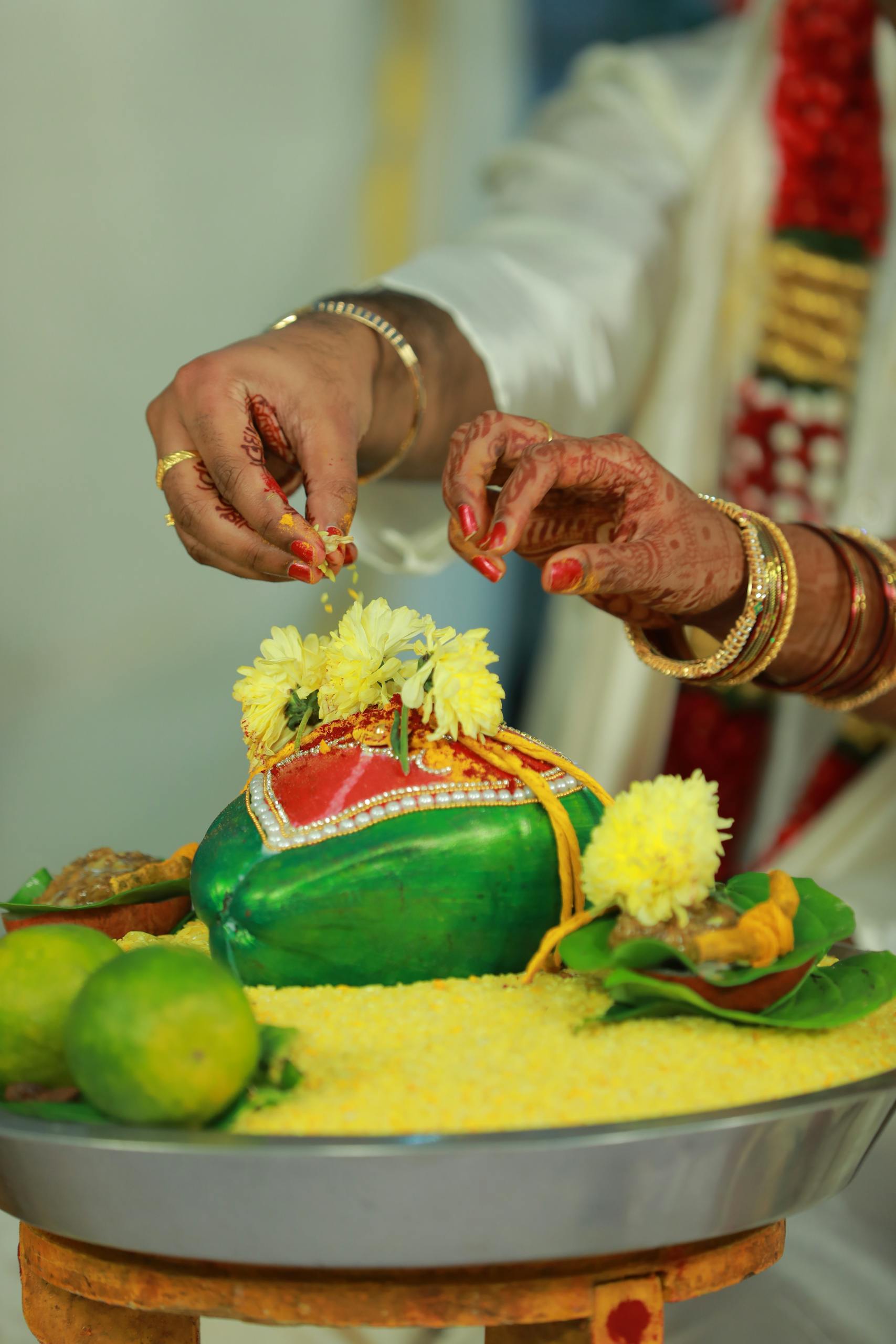 Close-up of hands performing a traditional Indian wedding ritual with flower petals.