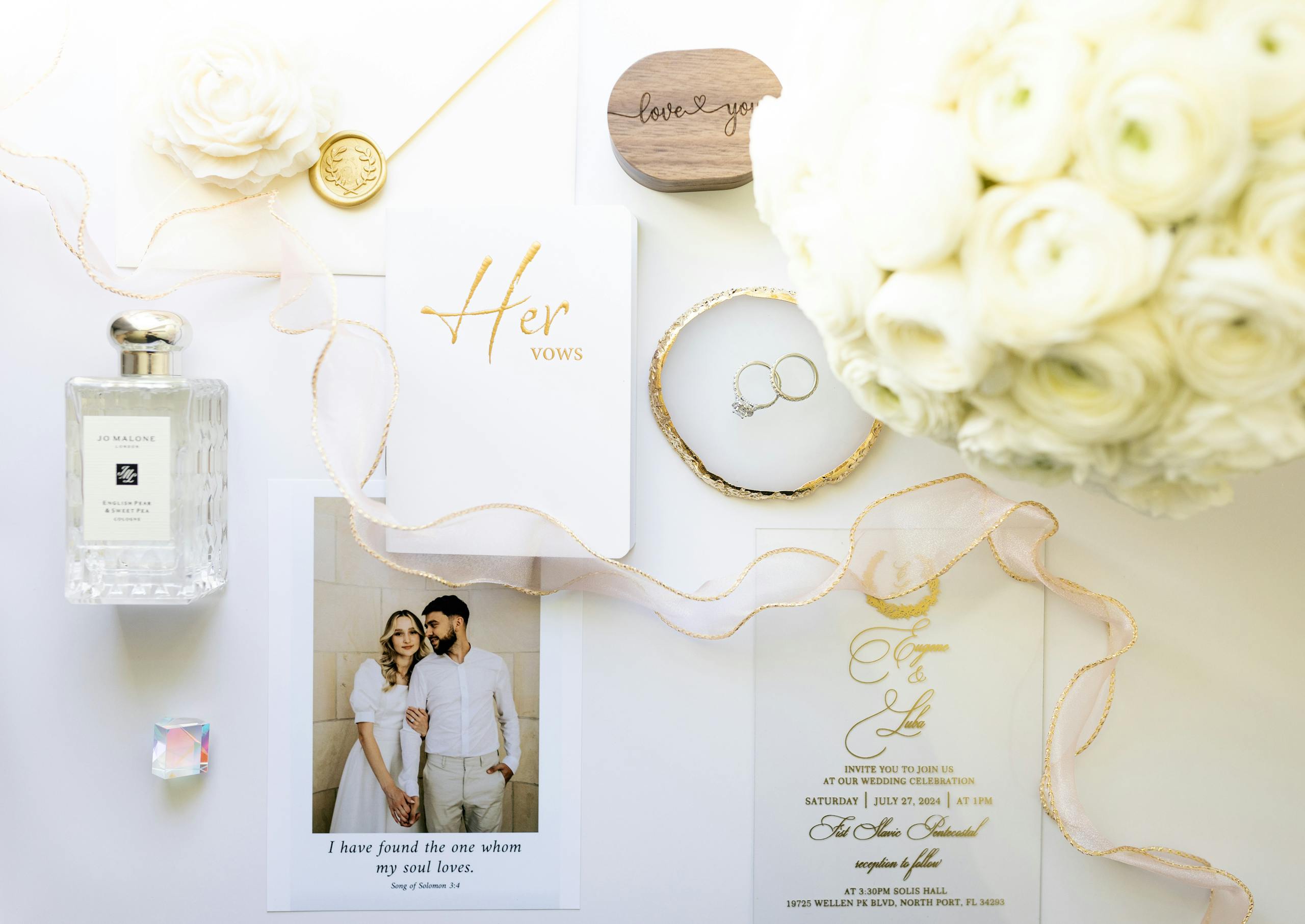 Sophisticated wedding flat lay featuring vows, rings, and florals in a minimalist design.